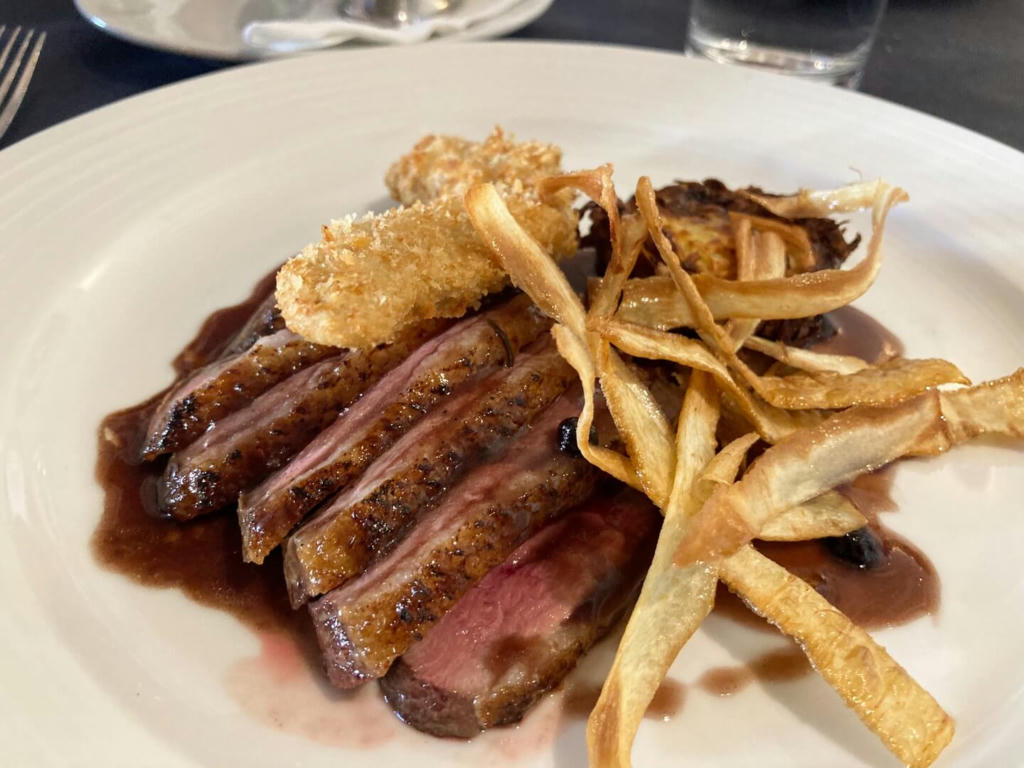 Duck Two Ways: Pan Fried Breast of Duck, Fillet of Duck in a Ginger Crumb, Blueberry and Ribera Wine Sauce, Potato Rosti and Green Vegetables - March 2023