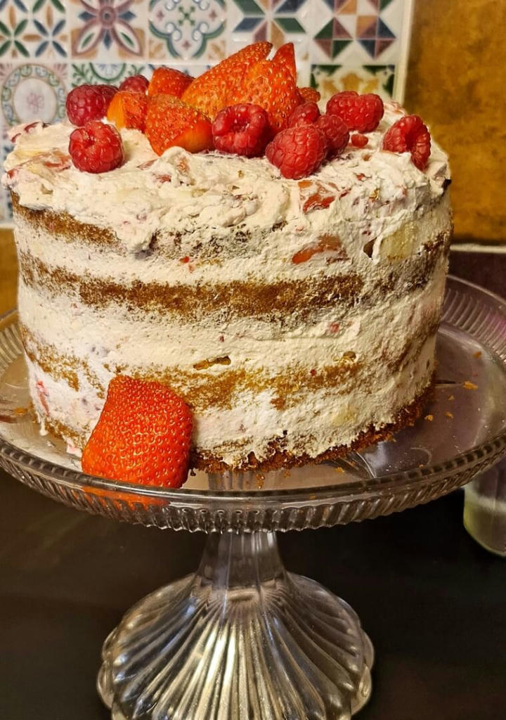 Eton Mess Cake. 4 layers of vanilla sponge, homemade strawberry jam and filled with cream, fresh strawberries, raspberries and meringue.