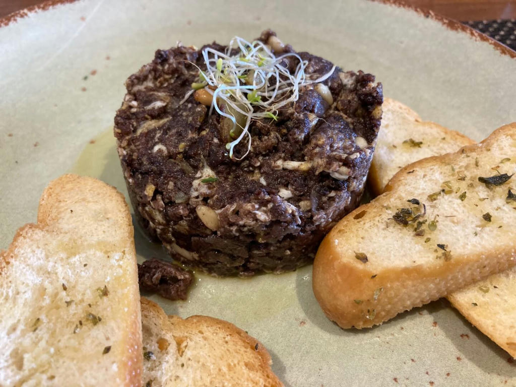 Scrambled egg with black pudding and pine nuts