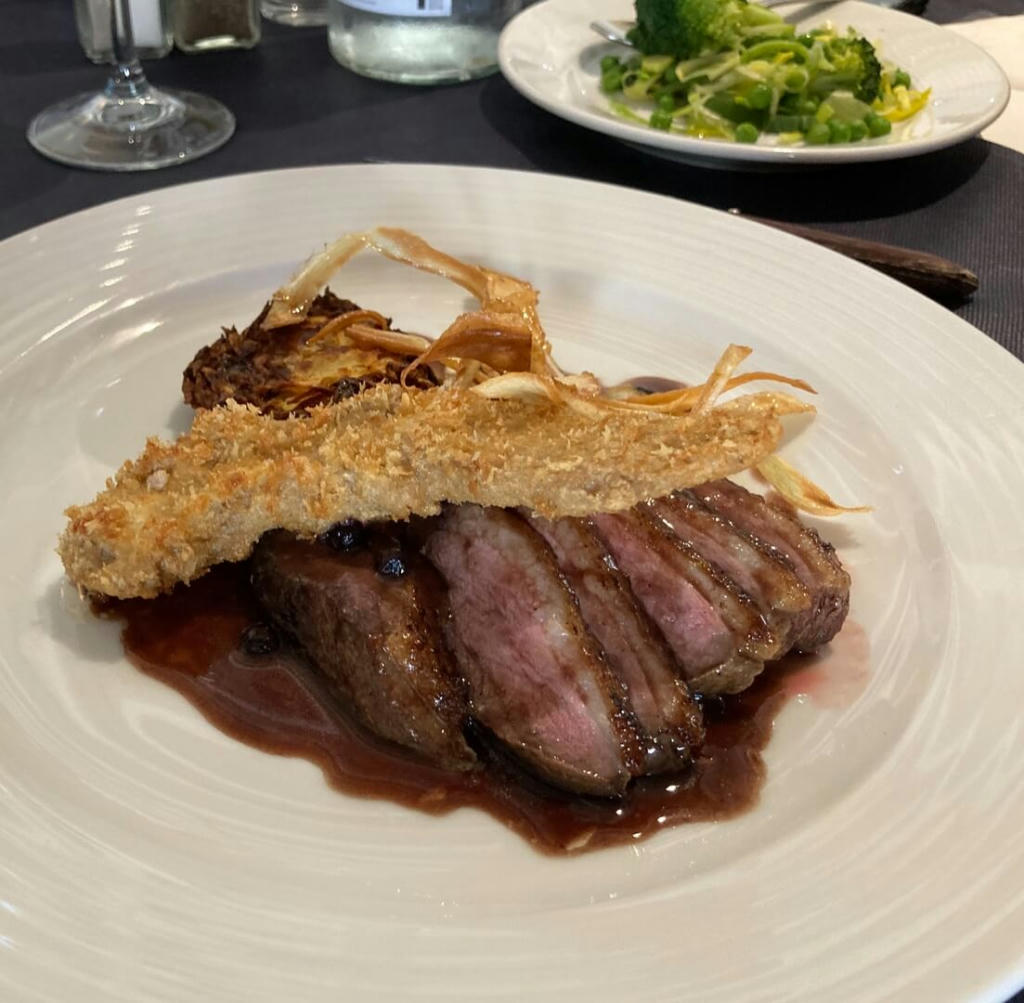 Duck Two Ways: Pan Fried Breast of Duck, Fillet of Duck in a Ginger Crumb, Blueberry and Ribera Wine Sauce, Potato Rosti and Green Vegetables - March 2023