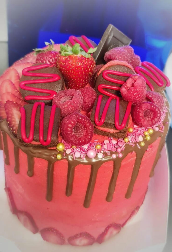 Layers of vanilla sponge, strawberry jam, vanilla buttercream. Decorated with fresh fruits and small chocolate biscuits.