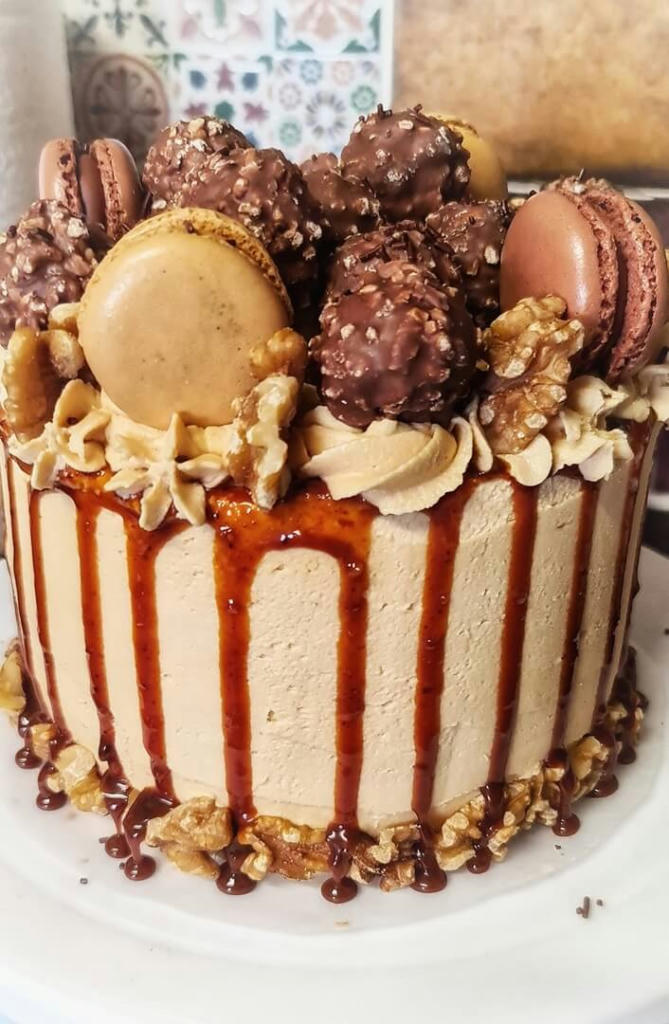 A 6inch caramel sponge filled with homemade salted caramel and caramel buttercream. Its decorated with a salted caramel drip, macarons, nuts and ferero rocher 