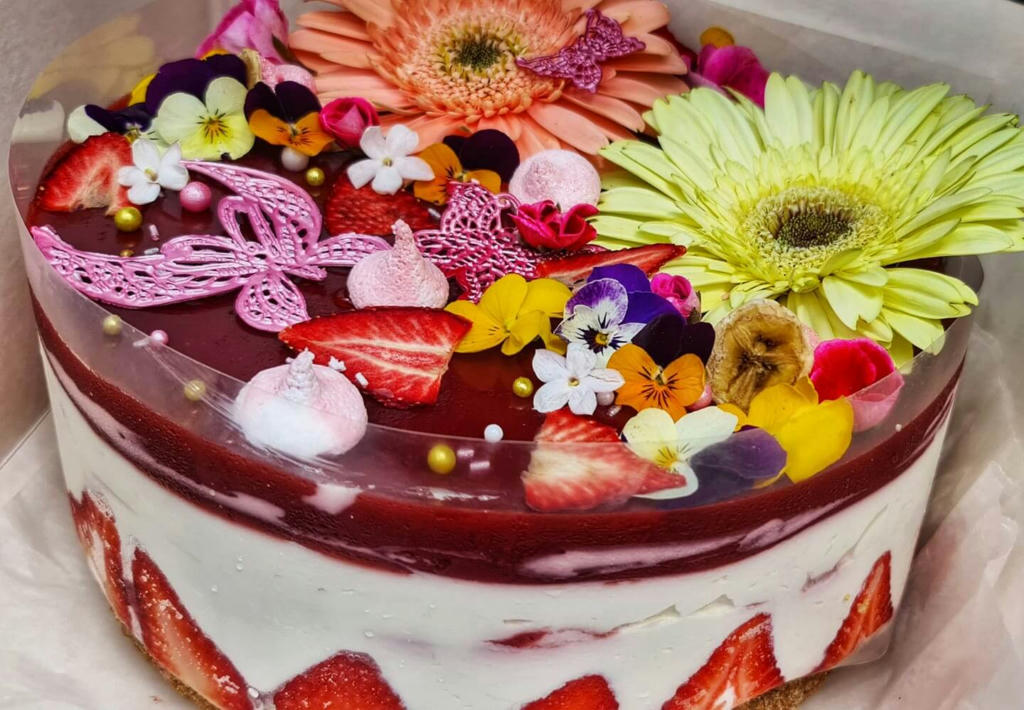 70th Birthday, not a cake this time as such but a cheesecake. This one was an extra deep creamy vanilla with a fresh strawberry swirl running throughout and a fresh strawberry purée jelly on top. Decorated with bright and colourful flowers.